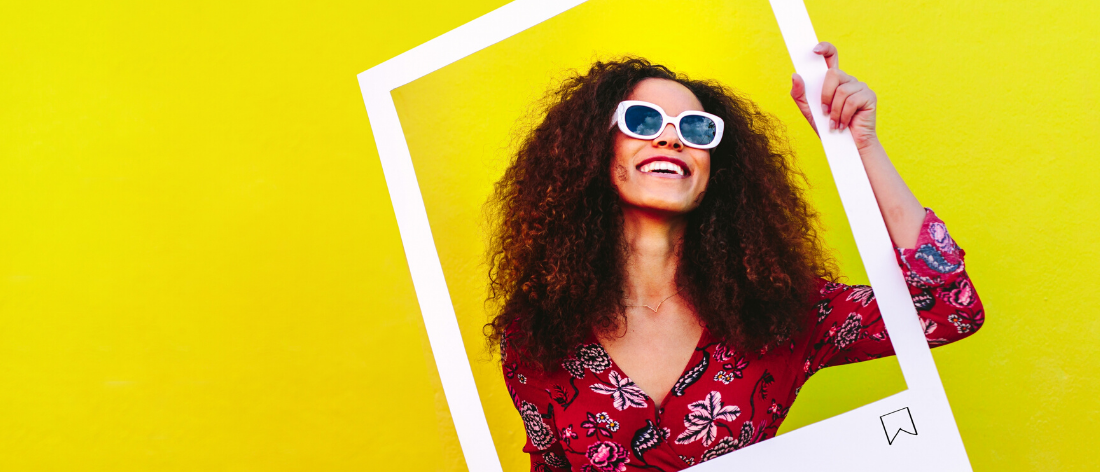 Woman holding social media frame yellow background - Rogers Advertising